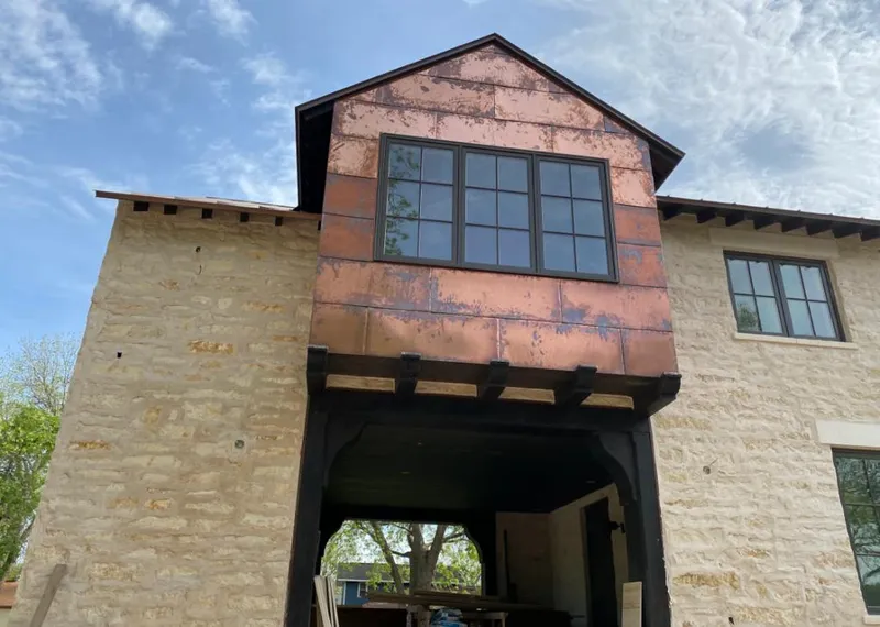 Copper metal panel facade on a stone building for Skylight Installation in Barrington