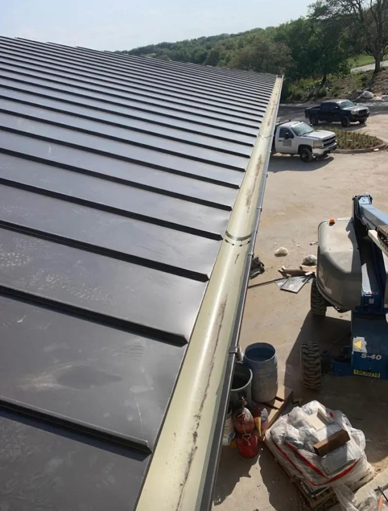 Standing seam panel and gutter detail on a metal roofing jobsite in Barrington
